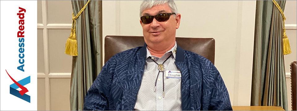 Douglas George Towne, Chair and CEO of Access Ready, Inc., sits at a board room table wearing sunglasses, smiling. To the left is the Access Ready, Inc. logo.